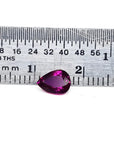 1.00-carat natural pear-shaped ruby gemstone, deep red, next to a ruler for scale.