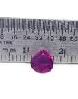 Pear cut natural ruby loose gemstone 1.19 carat, front side table and crown visibles on a ruler for scale