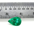 1.44 carat natural pear-cut Colombian emerald with a vibrant medium-deep green hue, shown next to a ruler.