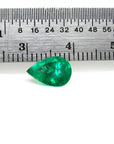1.44 carat natural pear-cut Colombian emerald with a vibrant medium-deep green hue, shown next to a ruler.