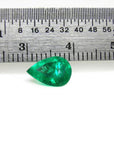 1.44 carat natural pear-cut Colombian emerald with a vibrant medium-deep green hue, shown next to a ruler.