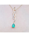 14K yellow gold twisted slider necklace with a pear-shaped emerald and diamond accents, shown worn on a person's neck.