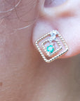 close-up of an emerald earring with double rope frame on an earlobe