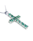 18k white gold cross pendant with natural colombian emeralds on a side profile position view.