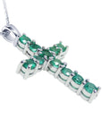 18k white gold cross pendant with natural colombian emeralds on a side profile position view.