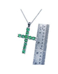 18K white gold cross pendant necklace with eleven round-cut Colombian emeralds, shown next to a ruler.