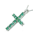 18K white gold cross pendant with eleven round-cut natural Colombian emeralds on a delicate chain.