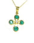 Gold necklace with a natural emeralds pendant on a topside position display.