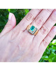 Men's 18K yellow gold ring with a rectangular emerald-cut Colombian emerald and channel-set princess-cut diamonds.