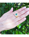 Men's 18K yellow gold ring with a rectangular Colombian emerald and channel-set princess-cut diamonds.