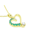 Gold heart-shaped pendant with natural emeralds and diamond on a topside view position.