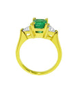 1.27 ct natural Colombian emerald three-stone ring in 18K yellow gold with trillion diamonds.