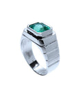 18K white gold men's ring with a bezel-set, modified emerald-cut deep bluish-green emerald.