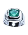 A 18k white gold men's solitaire emerald ring displaying its top bezel setting and sides profile.