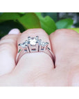 14K white gold engagement ring with a round center diamond and two trillion side diamonds.