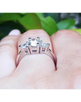 14K white gold engagement ring with a round center diamond and two trillion side diamonds.
