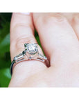 14k white gold engagement ring with a round diamond and two baguette side diamonds on a hand.