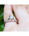 14k white gold engagement ring with a round diamond and two baguette side diamonds on a hand.