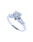 14k white gold engagement ring with a round diamond center and baguette side stones.