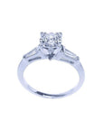 14k white gold engagement ring with a round central diamond and two baguette side diamonds.