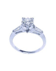 14k white gold engagement ring with a round central diamond and two baguette side diamonds.