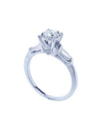 14k white gold engagement ring with a round central diamond and baguette side diamonds.