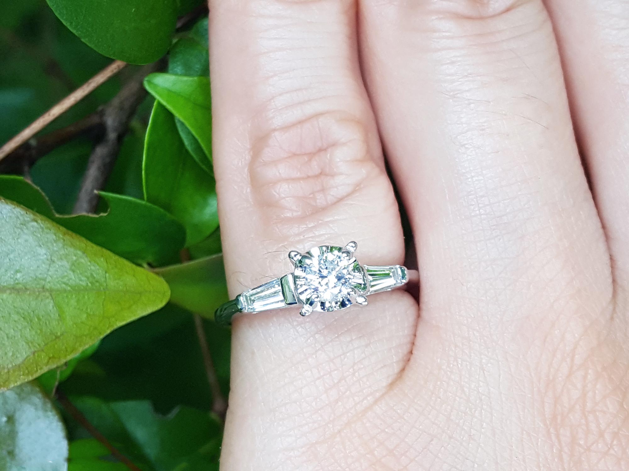 Round cut diamond three stone ring side tapper baguette
