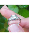14K white gold ring with a princess cut center diamond and two trillion side diamonds.