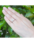 14K white gold ring with a princess cut diamond center and two trillion side diamonds on a hand.