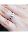 14K white gold three-stone ring with princess cut diamonds on a hand.