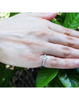 Heart cut diamond engagement ring with side baguette diamonds in 14K white gold on a hand.