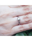 Round cut diamond solitaire engagement ring in 14K white gold on a hand.