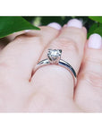 Round cut diamond solitaire engagement ring in 14K white gold on a hand.