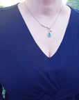 women's Colombian emerald necklace from the Muzo mines in Colombia, encircled in a halo of natural diamond set in 18k white gold