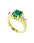 18K yellow gold ring with a GIA certified emerald and side trillion diamonds.
