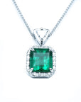 Encircled in a halo diamond a natural colombian emerald pendant square rectangular shape.