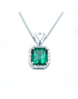 Encircled in a halo diamond a natural colombian emerald pendant square rectangular shape.