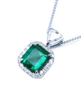 Displaying the topside this natural emerald pendant shows the halo diamond and the trillion-slider chain