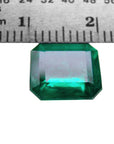 A natural colombian loose emerald with a ruler showing its size in millimeters.