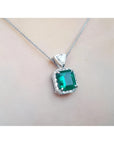 GIA certified Colombian emerald pendant in 18K white gold with diamond halo.