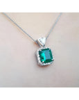 GIA certified Colombian emerald pendant in 18K white gold with diamond halo.