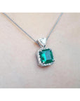 GIA certified Colombian emerald pendant in 18K white gold with diamond halo.