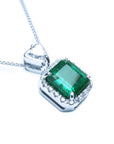Top and gallery profile view of a natural emerald pendant in 18k white gold.