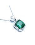 Top and gallery profile view of a natural emerald pendant in 18k white gold.