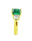 18K yellow gold ring with a GIA certified emerald and side trillion diamonds.