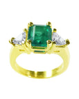 18K yellow gold ring with a GIA certified emerald and side trillion-cut diamonds.