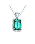 The topside of this certified natural emerald pendant shows the top bail slider with a trillion-cut diamond and the emerald with a halo diamond.