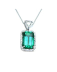 The topside of this certified natural emerald pendant shows the top bail slider with a trillion-cut diamond and the emerald with a halo diamond.