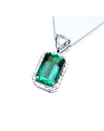 GIA certified Colombian emerald pendant with medium-deep green emerald-cut gem and diamond halo in 18K white gold.