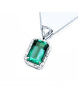 GIA certified Colombian emerald pendant with medium-deep green emerald-cut gem and diamond halo in 18K white gold.